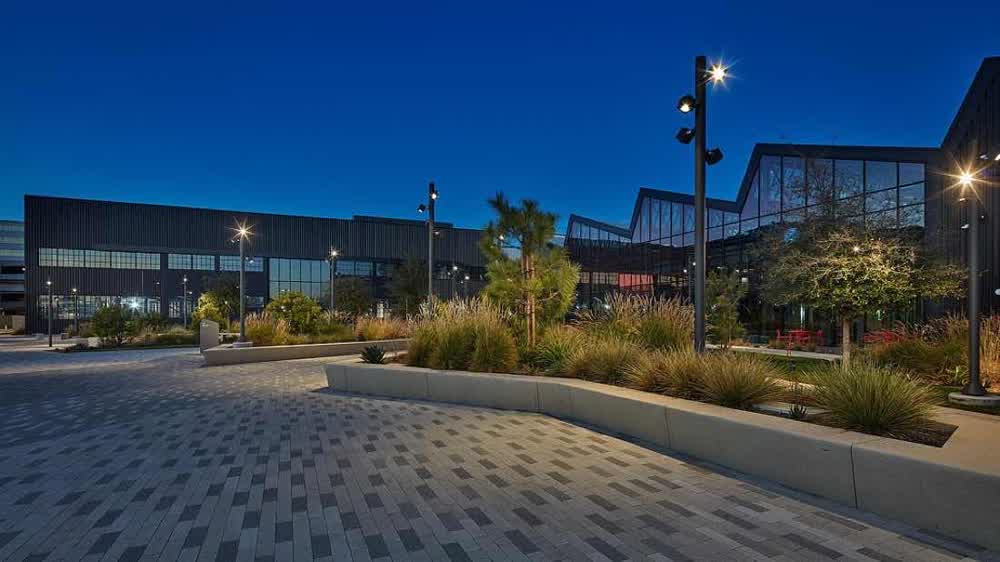 Adaptive reuse campus at blue hour with a planted seat wall