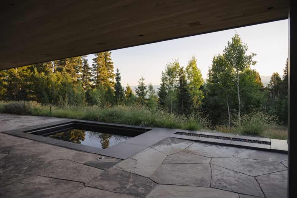 Reflecting pool and flagstone terrace opening to aspens at dusk